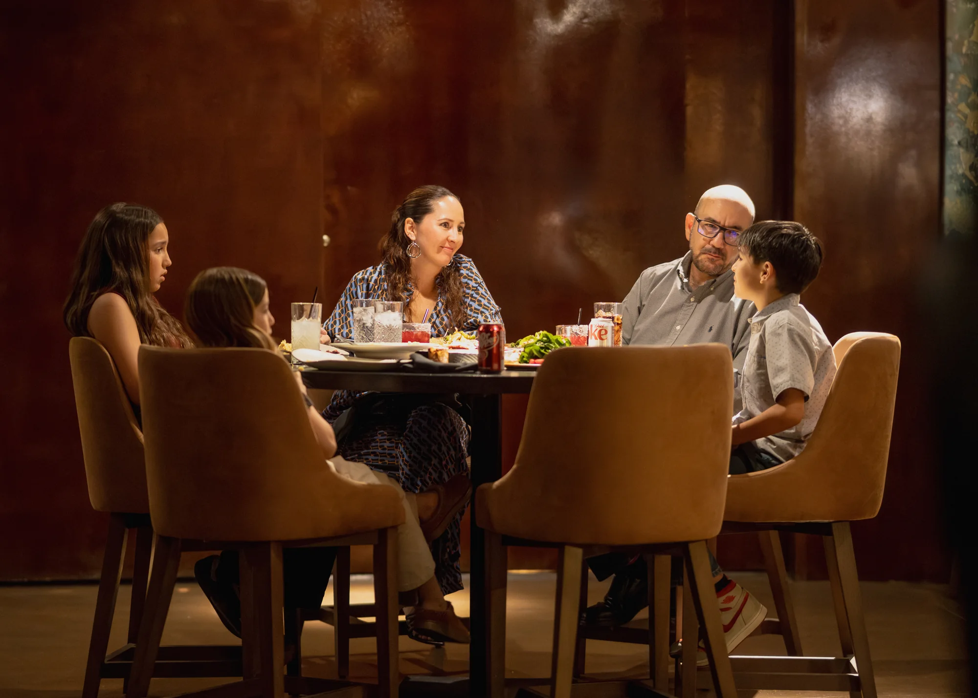 Guests gathered around a table in the warmly lit Origen Gilbert dining room.
